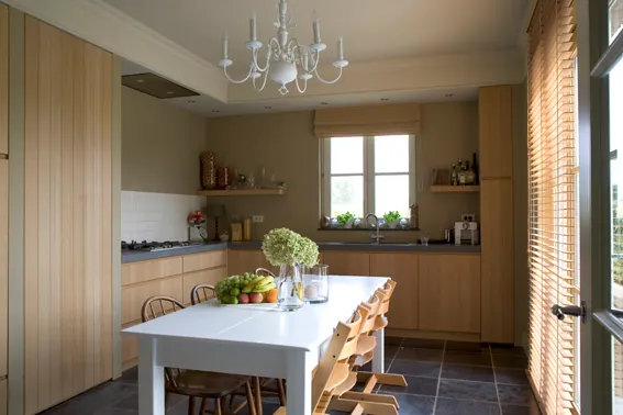 Lichte keuken met houten kasten en een witte eettafel